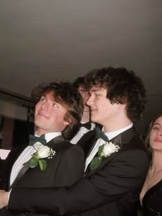 two young men in tuxedos standing next to each other