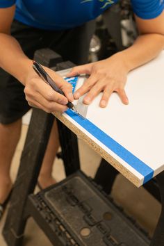 a person using a cell phone while sitting at a table with a piece of paper on it