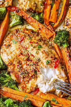 chicken, carrots, and broccoli on a sheet pan with a fork