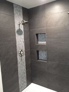 a walk in shower sitting next to a tiled wall