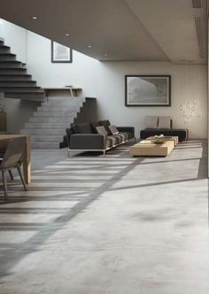 a living room filled with lots of furniture next to a stair case on the wall