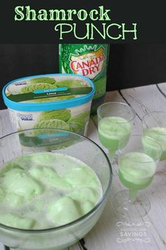 two glasses filled with green liquid next to ice cream and a can of shamrock punch