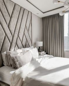 a bed with white sheets and pillows in a bedroom next to a window overlooking the city