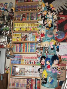 a shelf filled with lots of anime figurines next to a wall full of books