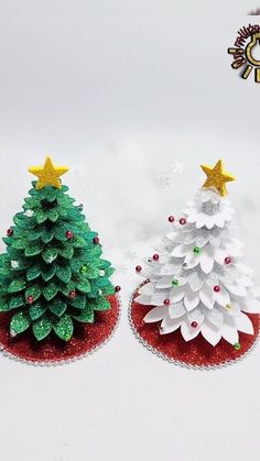 two small christmas trees sitting on top of each other in front of a white background