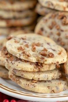 a stack of cookies on a plate with cranberries in the foreground and more cookies in the background