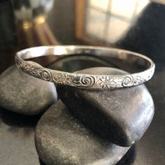 This listing is for one thick Sterling Silver floral Bangle Bracelet. This beautiful pattern bangle is 5.13mm wide and 1.78mm thick and is sure to be a unique addition to your favorite stacking bangle bracelets! This beautiful bangle is lovely and super strong. Stamped. All bangles are soldered, hammered, tumbled for hours and hand-polished just for you! My bangle sizes are available in the following sizes: Small - 2 1/4 inch diameter - Petite Adult 7 inch circumference Medium - 2 1/2 inch diame Elegant Round Stamped Bracelets, Elegant Stamped Bracelet, Elegant Stamped Bangle Bracelet, Elegant Stamped Bangle Jewelry, Ornate Stamped Bangle Bracelet, Wedding Stamped Bangle Bracelet, Handmade Flower Shaped Elegant Bangle, Handmade Elegant Flower Bangle, Bohemian Bracelets With Intricate Design For Anniversary