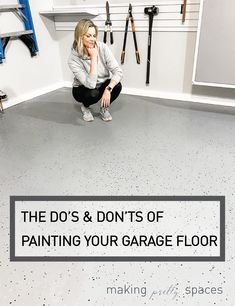 a woman kneeling on the floor in front of a garage floor with tools hanging up behind her