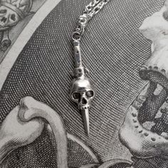 A dagger and skull necklace in sterling silver. Inspired by tattoo design and symbolism - death, protection and bravery.Chain length = 18", 20", 22"and 24"Skull pendant height = 27mmSterling SilverHandmade in NYC Dagger Necklace, Clothing Art, Halloween Vampire, Gothic Horror, Dark Gothic, Skull Necklace, Skull Pendant, Skull Ring, Film Serie