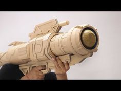 a man is holding a model of a telescope