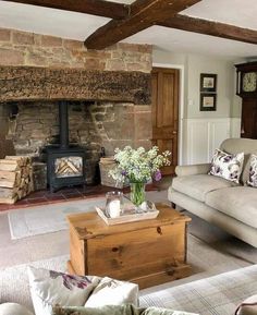 a living room filled with furniture and a fire place in the middle of it's wall