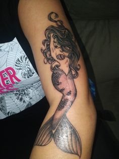 a woman with a mermaid tattoo on her arm