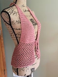 a mannequin wearing a pink crochet purse