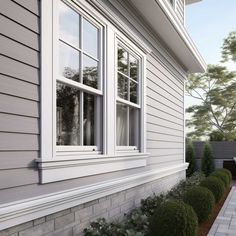 an exterior view of a house with white siding and two large windows on the side