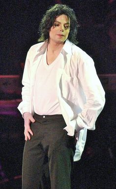 michael jackson in white shirt and black pants with his hands on his hips while standing