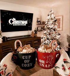 two buckets filled with marshmallows sitting in front of a christmas tree