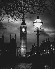 the big ben clock tower towering over the city of london at night with clouds in the background