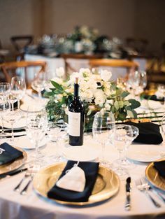 the table is set with white plates and place settings for an elegant dinner party or celebration