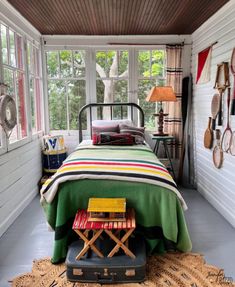 a bed room with a neatly made bed next to a window and a rug on the floor