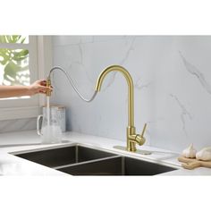 a person is holding a faucet over a sink