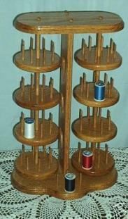 a wooden spinning wheel with several spools of thread on the top and bottom