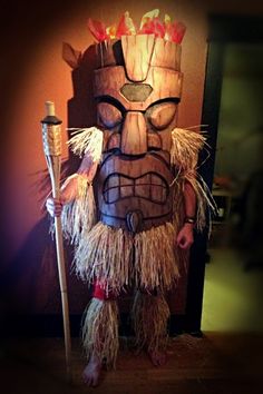 a man in a tiki costume holding a stick