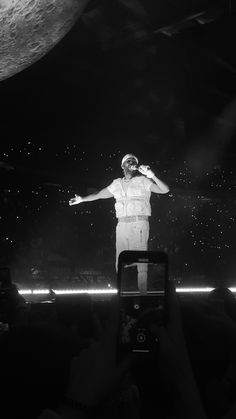 a man standing on top of a stage with his arms outstretched in front of him