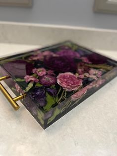 a glass tray with flowers on it sitting on a counter