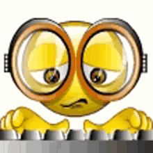 a yellow smiley face with large round glasses on it's head and hands behind a metal fence