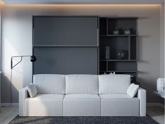 a white couch sitting in front of a book shelf on top of a carpeted floor