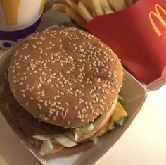 a hamburger and french fries are on a plate next to a mcdonald's cup