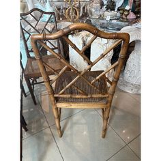 a wooden chair sitting on top of a tile floor next to a table with chairs