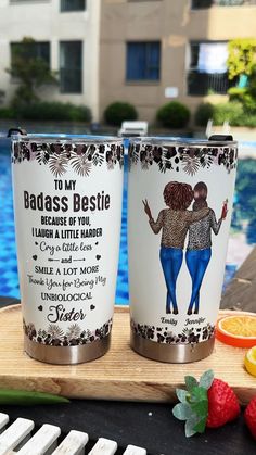 two personalized tumblers sitting next to each other on a table near a pool