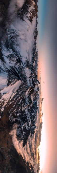 the view from an airplane looking down on snow covered mountains