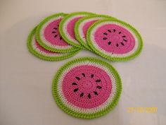 four pieces of crocheted watermelon coasters on a white table top