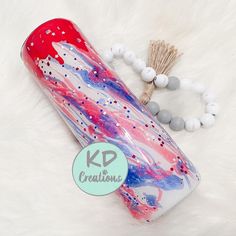 a red, white and blue water bottle next to a beaded bracelet