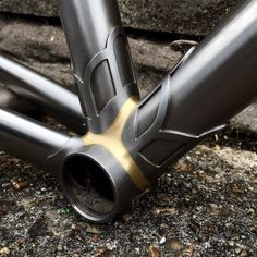 the bottom section of a bike with gold accents on it's rims and seatposts