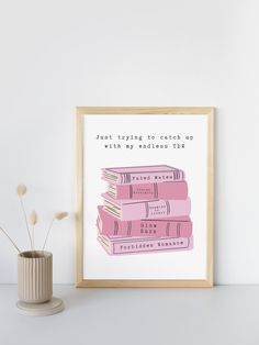 a stack of books sitting on top of a table next to a vase