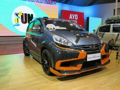 an orange and black car on display in a showroom