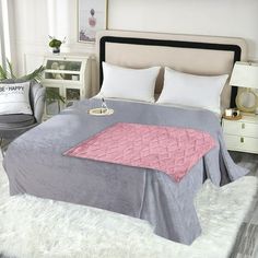 a bed with a blanket and pillows on top of it