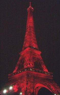 the eiffel tower is lit up in red