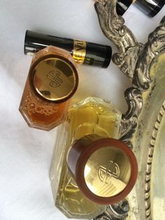 an assortment of perfumes sitting on top of a silver tray next to a mirror