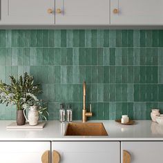 a kitchen with green tiles on the wall