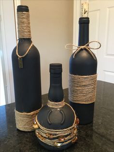 two black bottles with rope wrapped around them