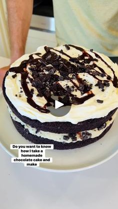 a cake with white frosting and chocolate toppings on it sitting on a plate