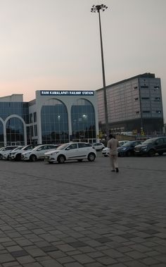 a parking lot with cars parked in front of it and people walking around the area