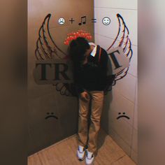 a person leaning against a wall with wings on it