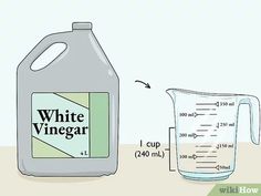 a jug of white vinegar next to a measuring cup with liquid in it and labeled whinegar on the side