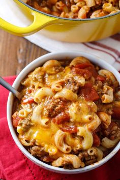 a bowl filled with macaroni and cheese next to a casserole dish