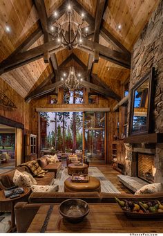 a living room filled with lots of furniture and a chandelier hanging from the ceiling